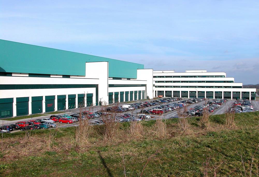 AMD Saxony fab buildings in Dresden in 2007, white halls with a teal roof band and a large car park