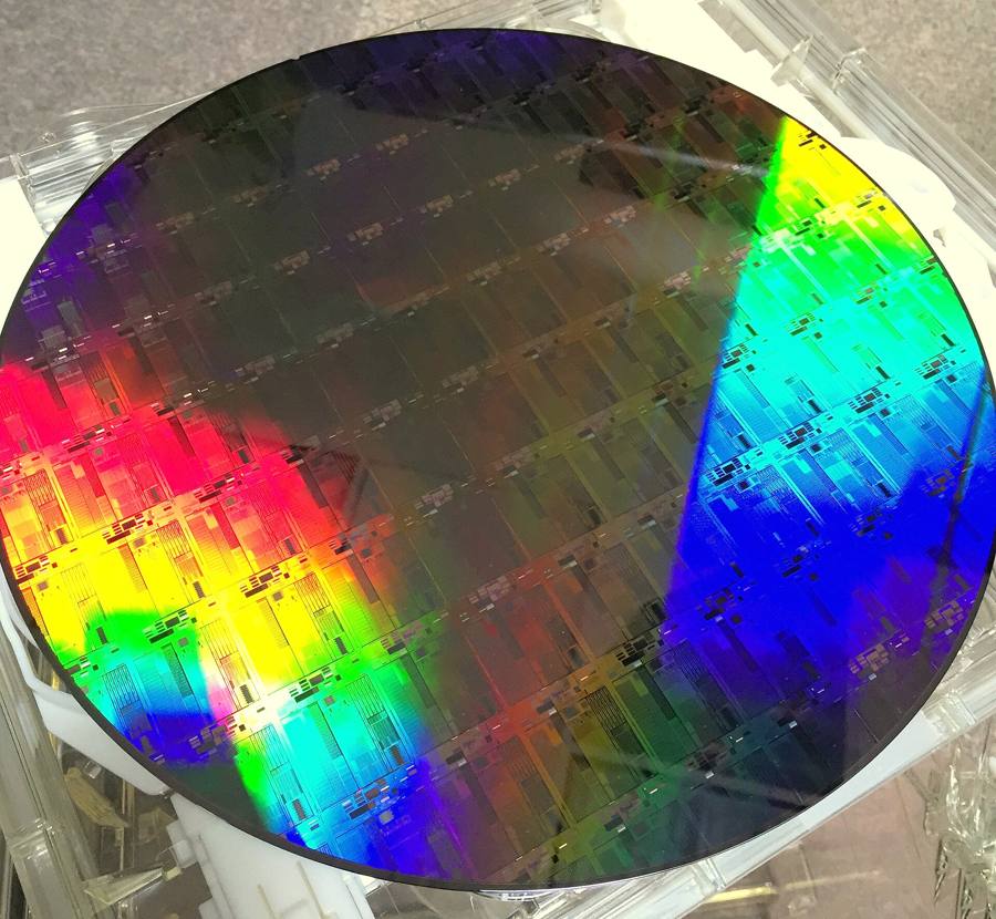 A 300mm silicon photonics wafer showing rainbow diffraction across patterned die
